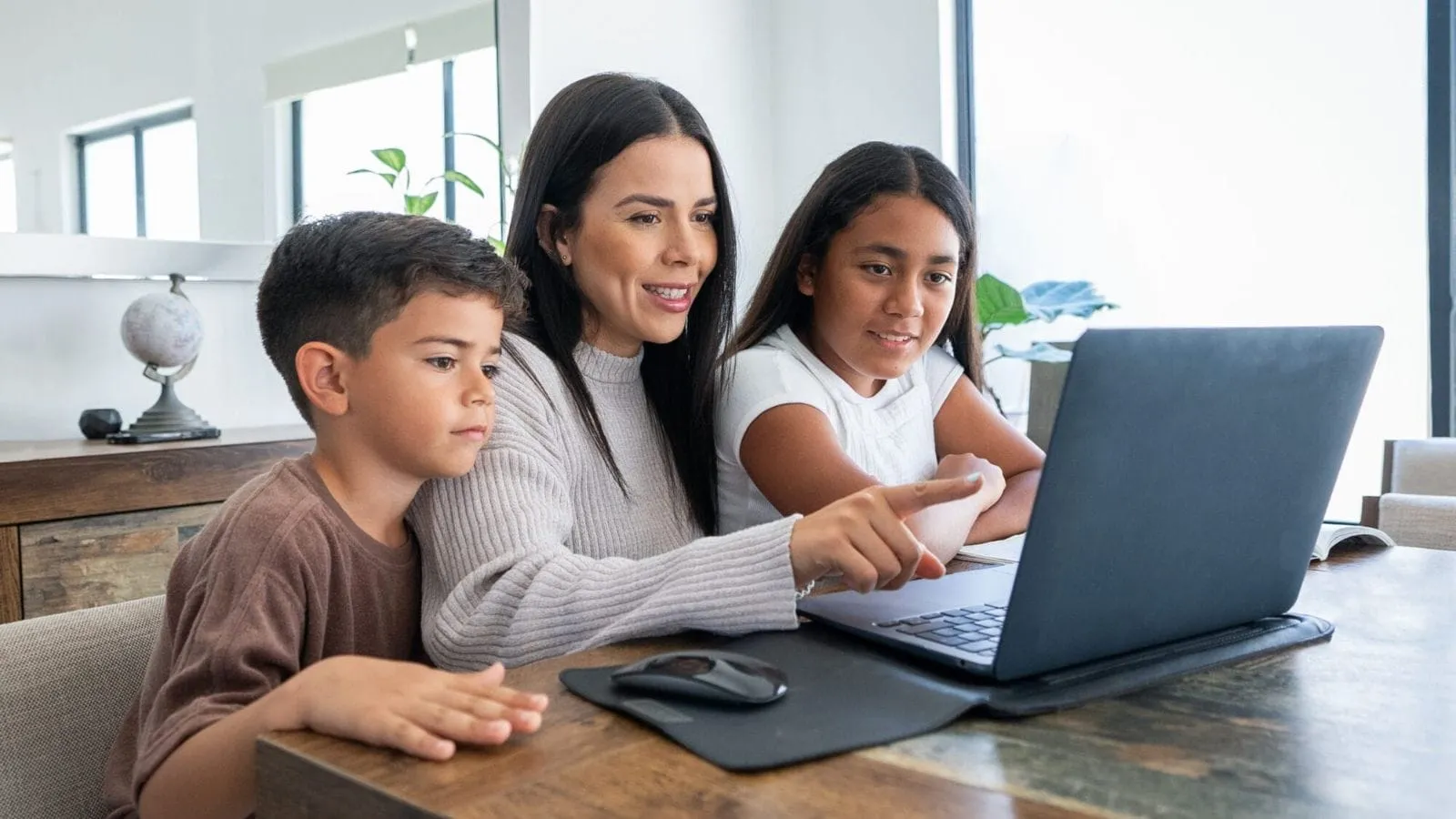 Woman looking at laptop with her daughter and son