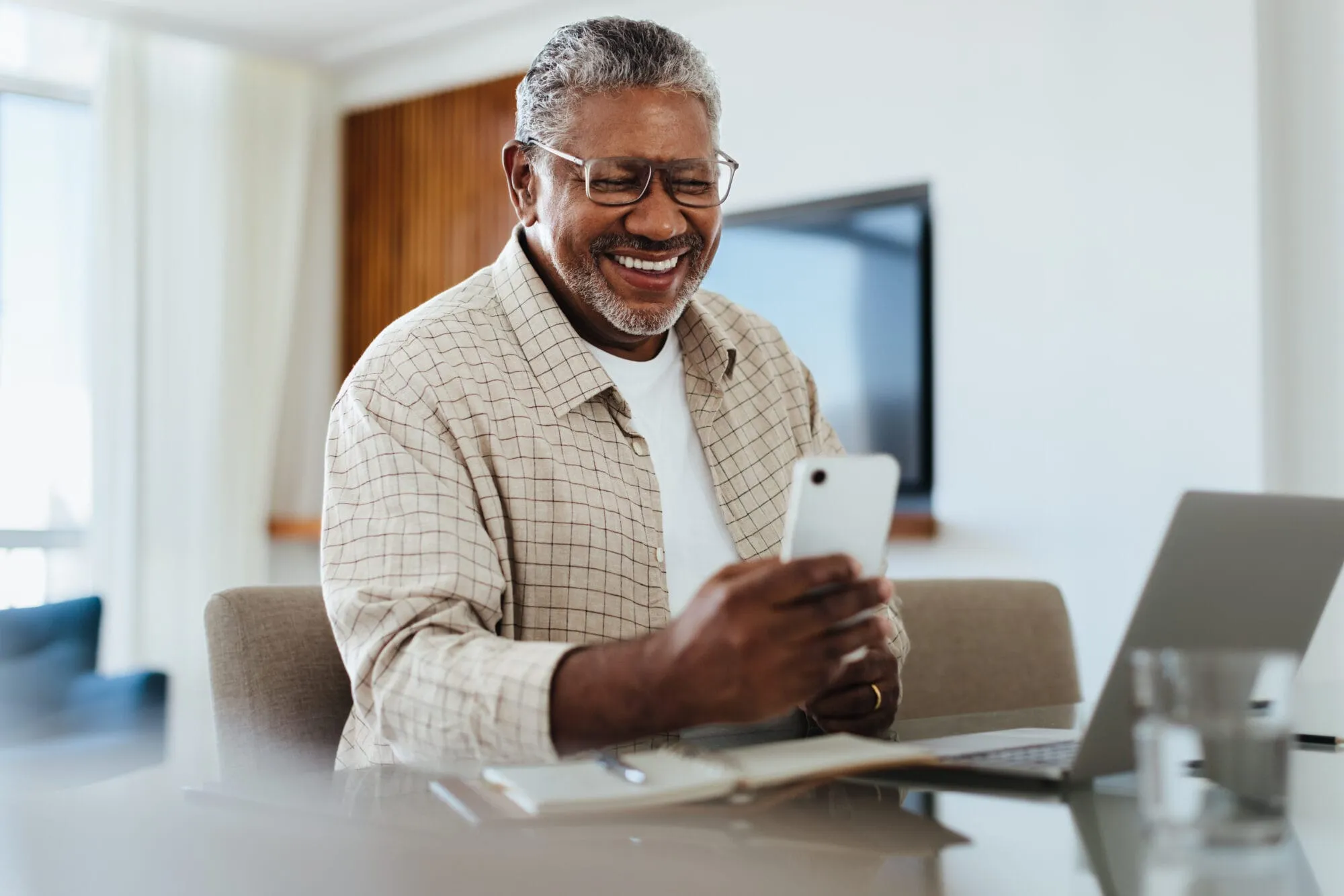 Happy mature male using phone for connecting and staying in touch